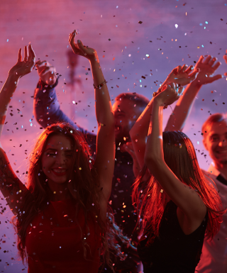 group of people dancing with confetti falling