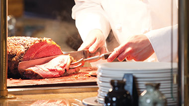 Chef hands carving prime rib