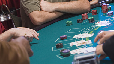 Blackjack table with people playing at it.